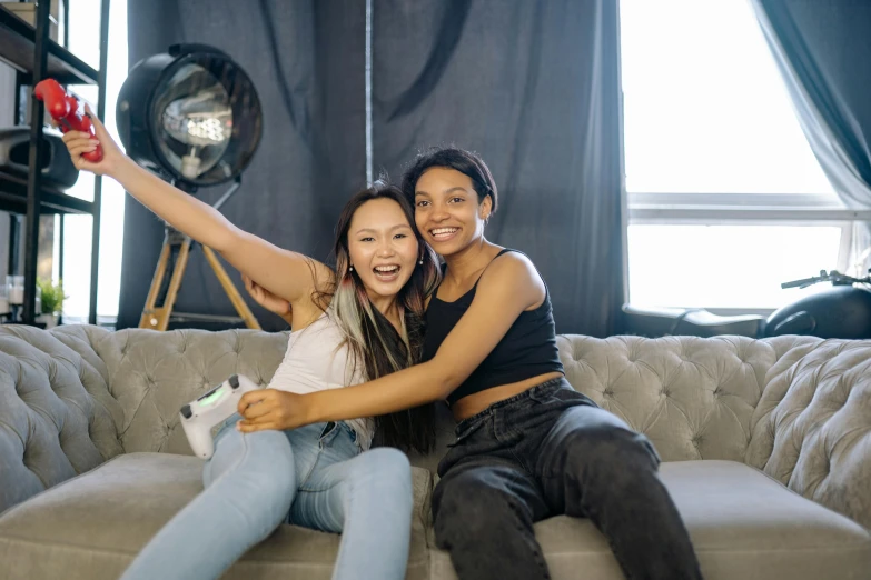 a couple of women sitting on top of a couch, pexels contest winner, tiktok, ashteroth, joy ang, background image
