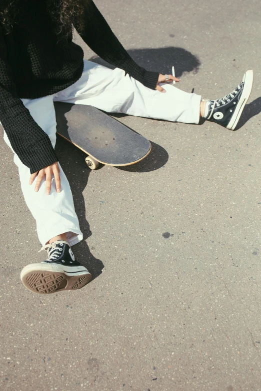 a woman sitting on the ground with a skateboard, trending on unsplash, photorealism, converse, non-binary, black canvas, flat colour