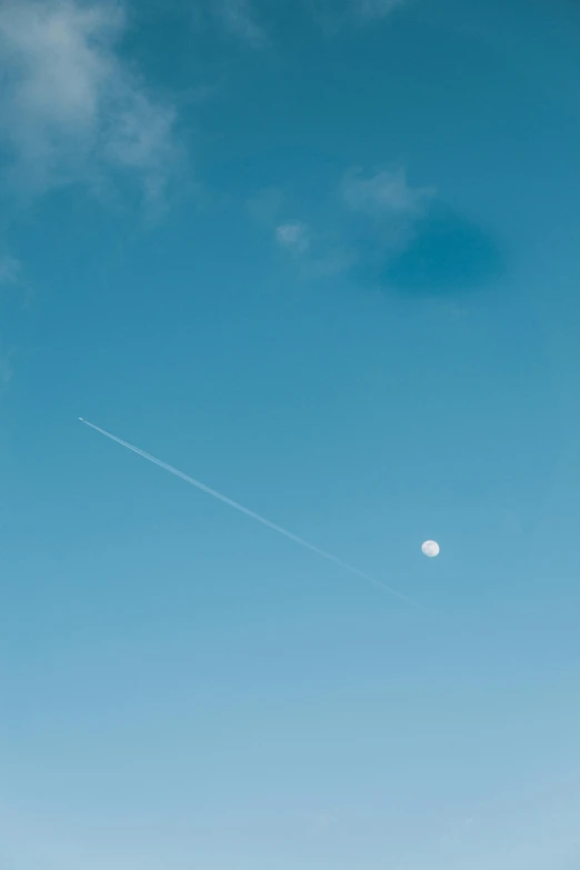 a man flying a kite on top of a lush green field, by Niko Henrichon, pexels contest winner, postminimalism, the moon, plane light, sky blue, meteor