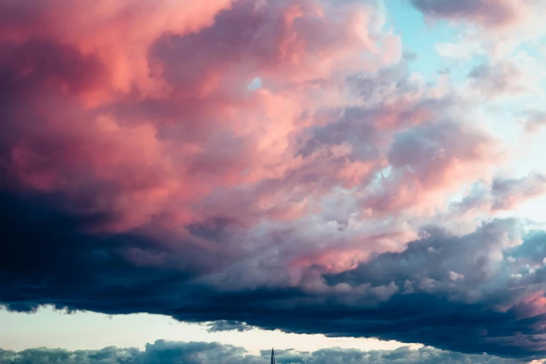 a large body of water under a cloudy sky, a picture, unsplash, romanticism, pink storm clouds, light red and deep blue mood, dark towering clouds, journalism photo