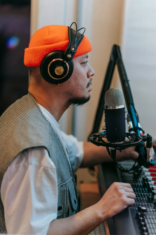 a man wearing headphones sitting in front of a microphone, quy ho, studio orange, lightly dressed, trending on artsstation