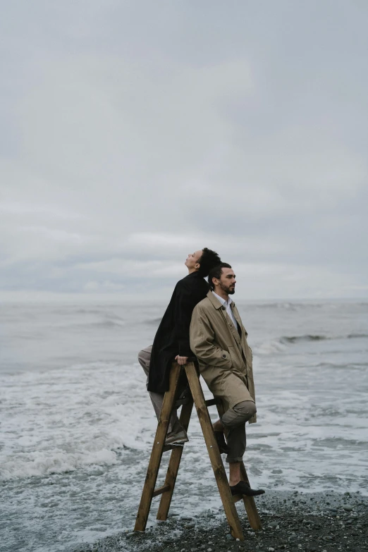 a man sitting on top of a ladder next to the ocean, by Niko Henrichon, pexels contest winner, romanticism, man and woman walking together, on a gray background, ride the wind and waves, 15081959 21121991 01012000 4k