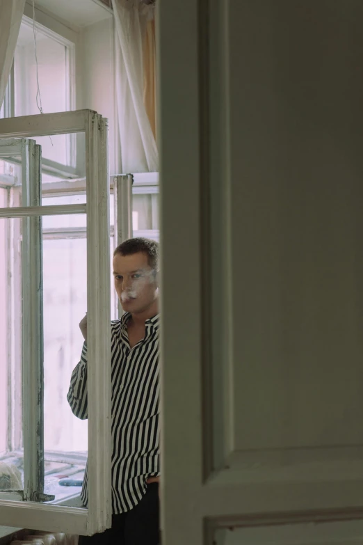 a man standing in front of a window brushing his teeth, inspired by Henri-Julien Dumont, striped, taking a smoke break, ( ( theatrical ) ), anna nikonova