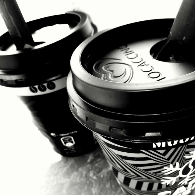 a couple of cups sitting next to each other, a black and white photo, lyco art, @ cronobreak on twitter. com, black color scheme, closeup!!!!!, ice coffee