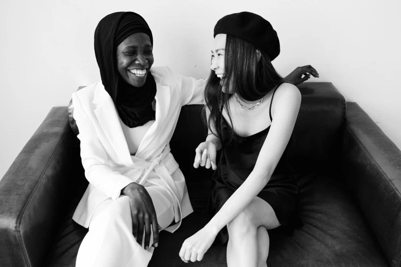 a black and white photo of two women sitting on a couch, pexels contest winner, diverse outfits, white hijab, happy friend, korean woman