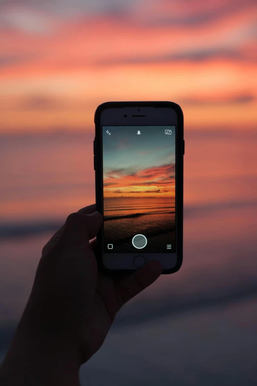 a person taking a picture of a sunset with their cell phone, a picture, pexels contest winner, photo of the middle of the ocean, iphone in hand, sunset with cloudy skies, - i