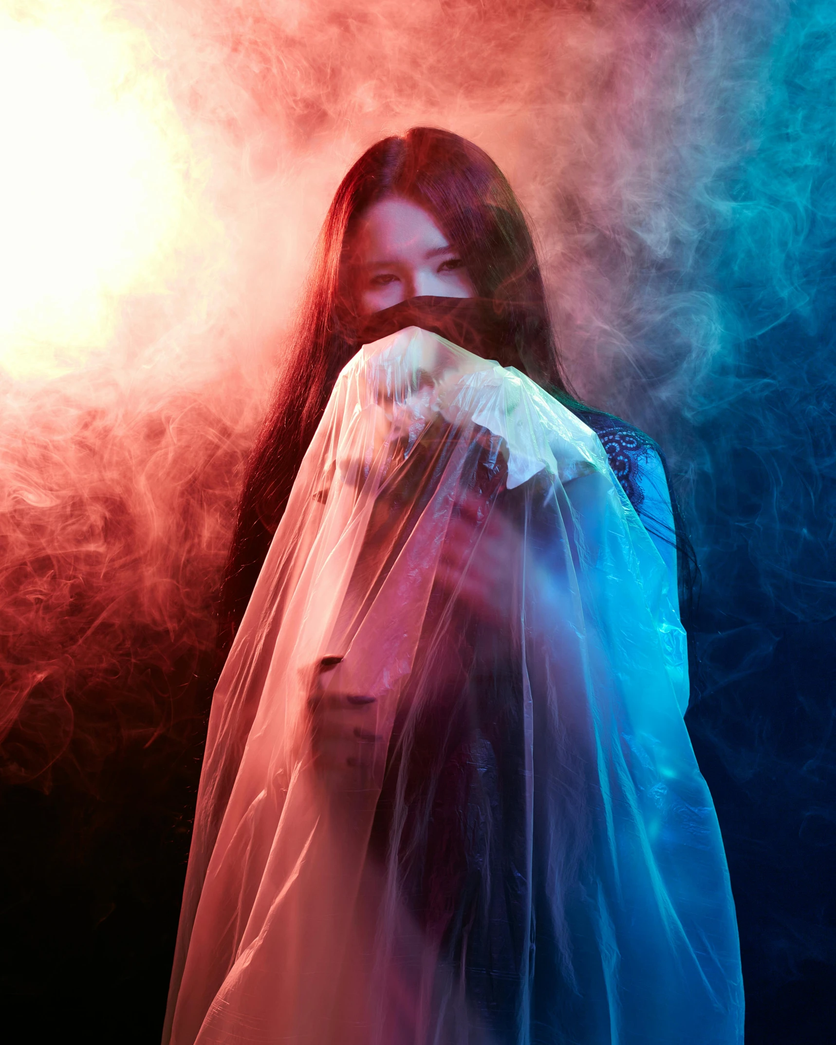 a woman standing in a smoke filled room, an album cover, inspired by Elsa Bleda, pexels contest winner, iu lee ji-eun as a super villain, diaphanous iridescent silks, woman holding another woman, red and blue back light