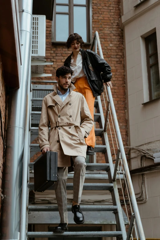 a man and a woman walking up a set of stairs, pexels contest winner, bauhaus, light brown trenchcoat, male model, luggage, thumbnail