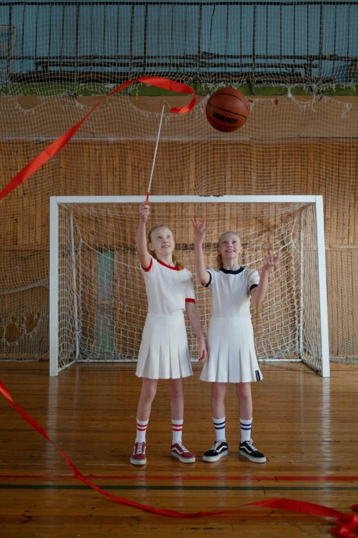 a couple of girls standing next to each other on a basketball court, socialist realism, hanging from the ceiling, still from a live action movie, anna nikonova aka newmilky, ussr