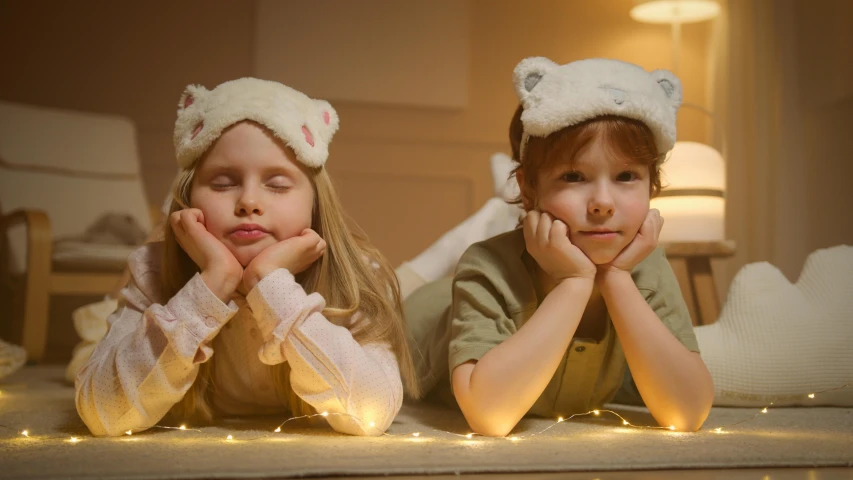 a couple of kids laying on top of a bed, by Adam Marczyński, trending on pexels, magical realism, fox ears, soft lighting 8k, long night cap, goldilocks