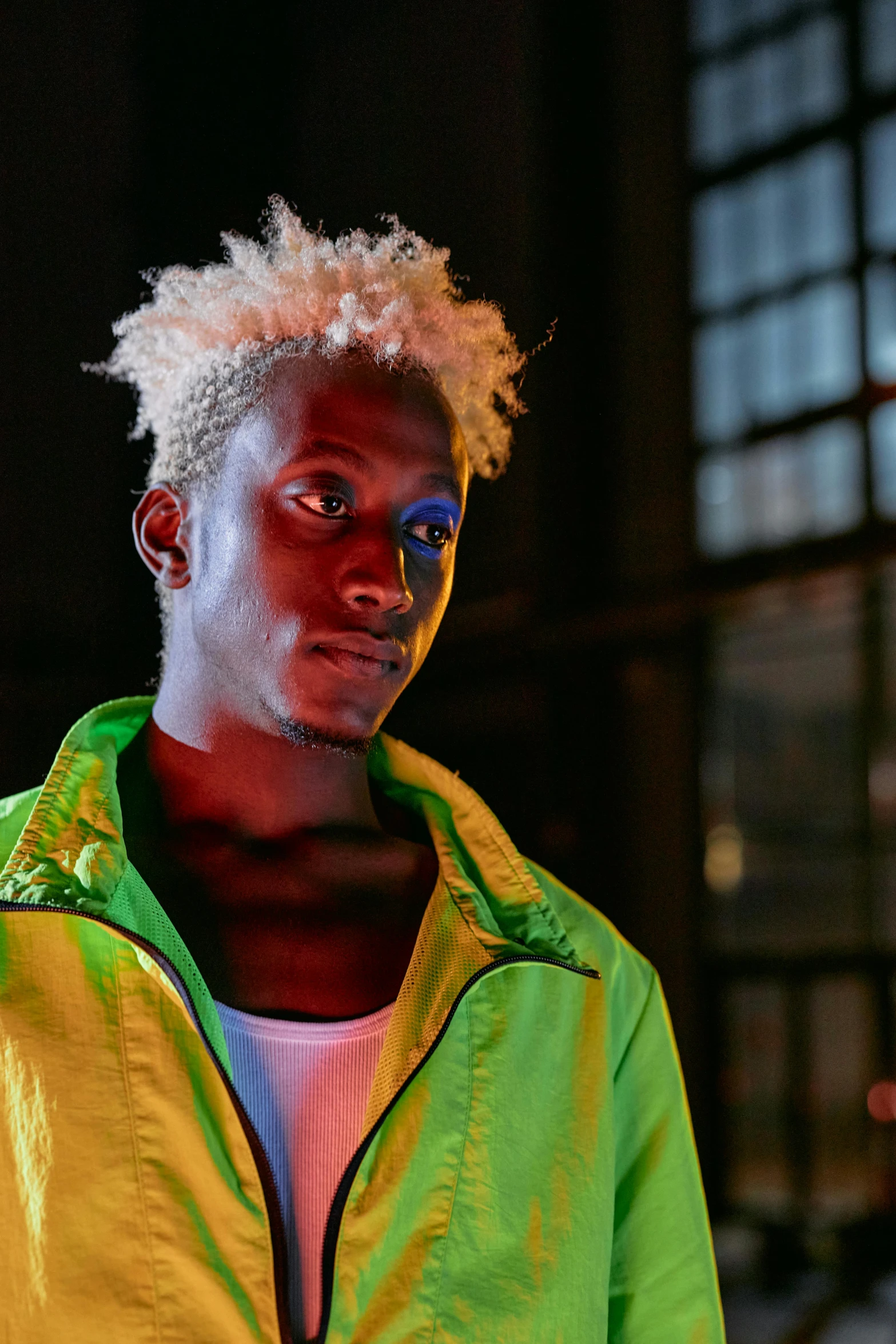 a close up of a person wearing a jacket, trending on pexels, afrofuturism, white neon wash, blond boy, ( ( dark skin ) ), brightly-lit