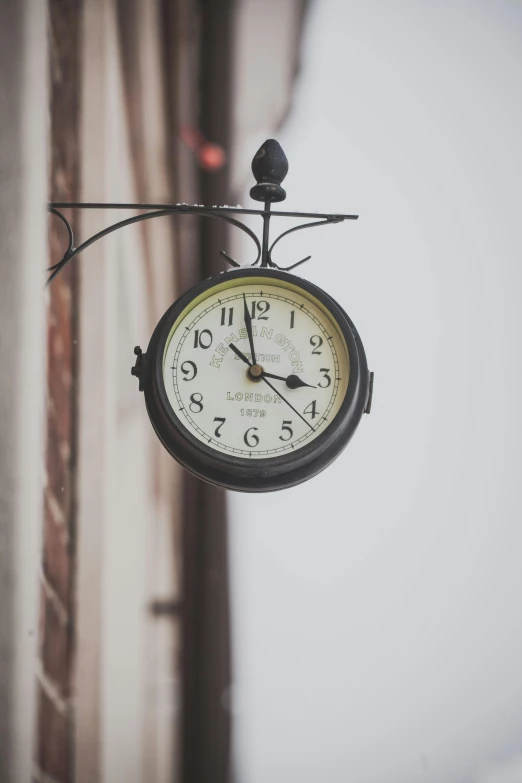 a clock hanging from the side of a building, profile image, street light, thumbnail, brown