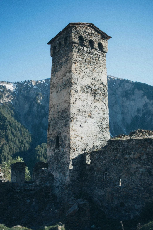 a tall tower sitting on top of a lush green hillside, by Sebastian Spreng, romanesque, destroyed mountains, alps, deteriorated, photographs