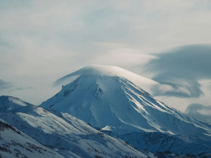 a mountain covered in snow under a cloudy sky, an album cover, by Muggur, pexels contest winner, hurufiyya, active volcano, nekro petros afshar, profile picture 1024px, fan favorite