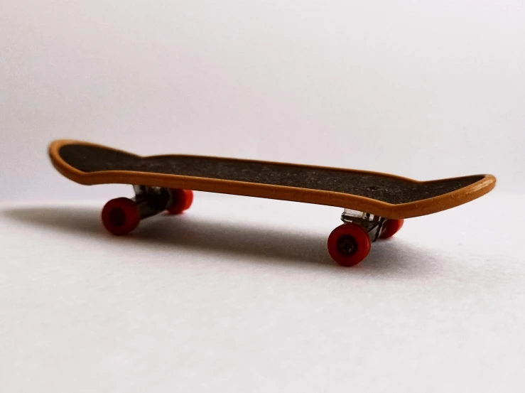 a close up of a skateboard on a white surface, by Gavin Hamilton, unsplash, hyperrealism, micro machines, hand carved, toy design, on a pale background