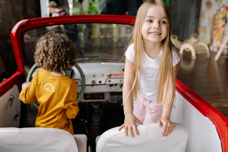 a little girl sitting in the back of a red car, pexels contest winner, two girls, 15081959 21121991 01012000 4k, kombi, white background