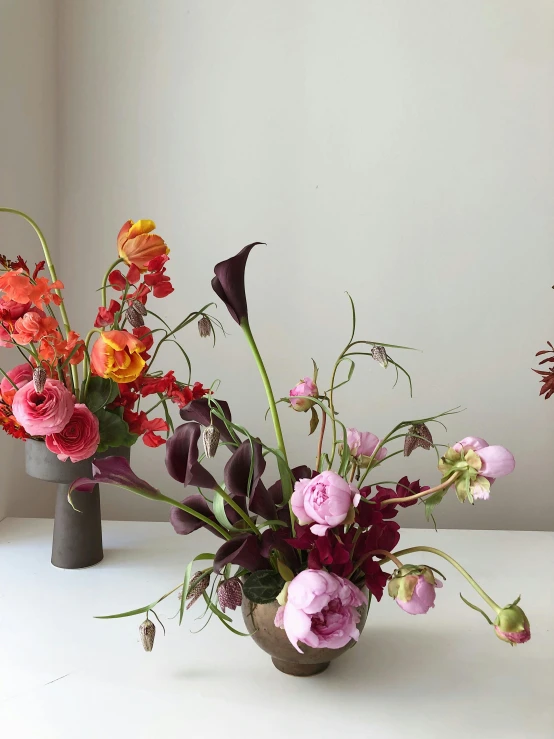 a couple of vases sitting on top of a table, by Jessie Algie, floating bouquets, in rich color, botanicals, medium height