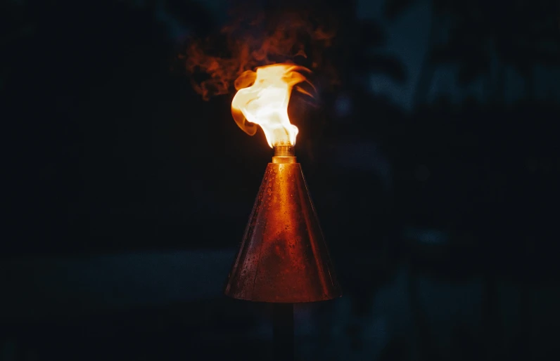 a torch is lit in the dark, an album cover, pexels contest winner, visual art, cone shaped, 8k 50mm iso 10, tiny firespitter, early morning lighting