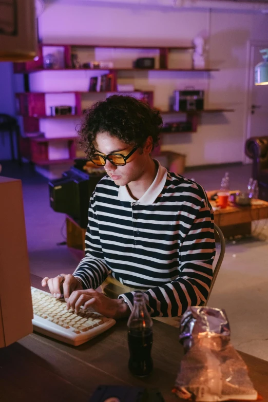 a woman sitting at a table typing on a computer, non-binary, cynthwave, high quality photo, raphael personnaz