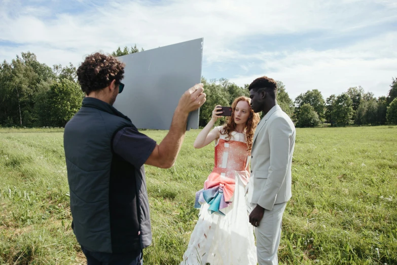 a man taking a picture of a woman in a wedding dress, unsplash, photorealism, adut akech, midsommar color theme, large format photograph, sadie sink