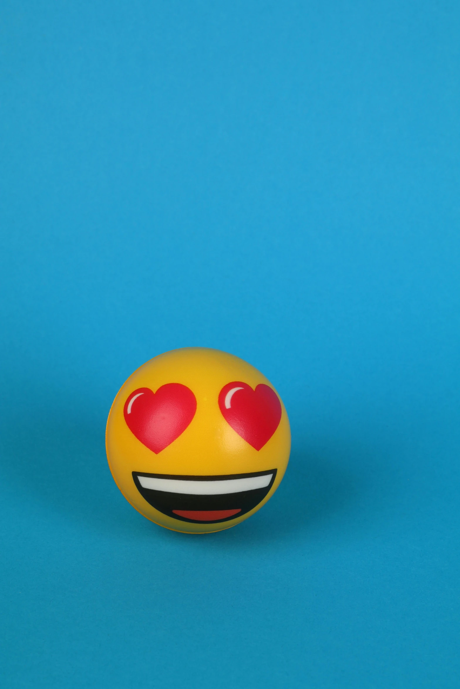 a smiley face with heart eyes on a blue background, by Gavin Hamilton, trending on pexels, inflatable, on a gray background, kiss, ball