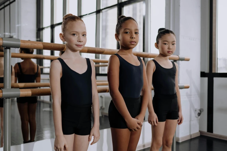 a group of young girls standing next to each other, by Winona Nelson, pexels contest winner, american barbizon school, wearing leotard, black, promo image, diverse ages
