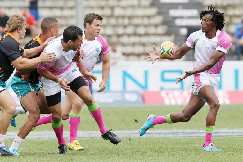 a group of men playing a game of rugby, pink white and green, press release, rosen zulu, start of the match