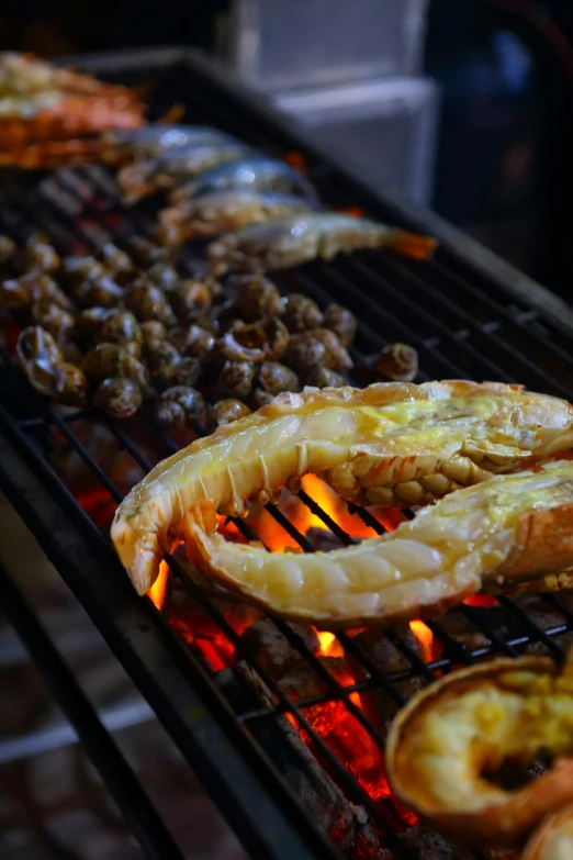 a grill topped with lots of different types of food, by Basuki Abdullah, unsplash, prawn, oman, burning, low detailed