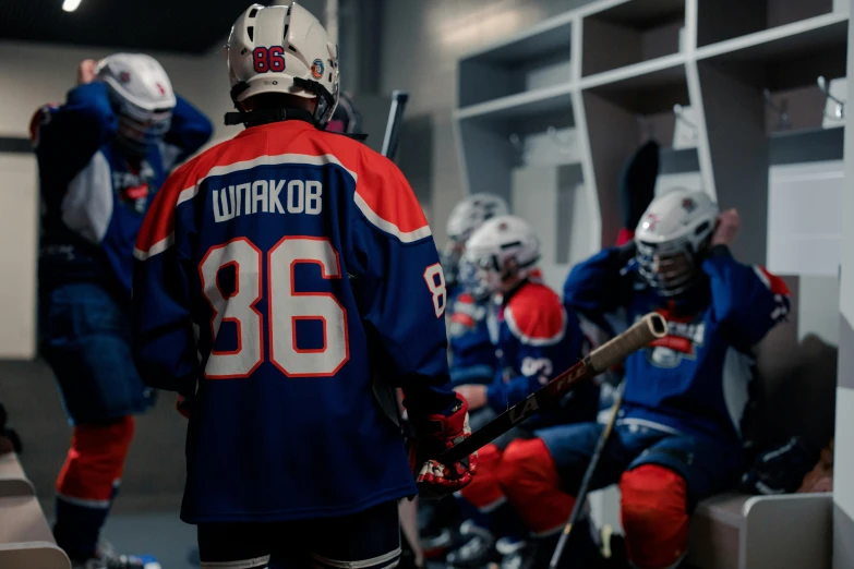 a group of hockey players sitting in a locker, inspired by Jakub Husnik, pexels contest winner, slovakia, uniform background, teaser, thumbnail