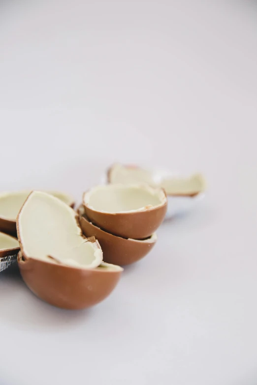 a couple of bowls sitting on top of a table, chocolate, cracked, easter, with a white background