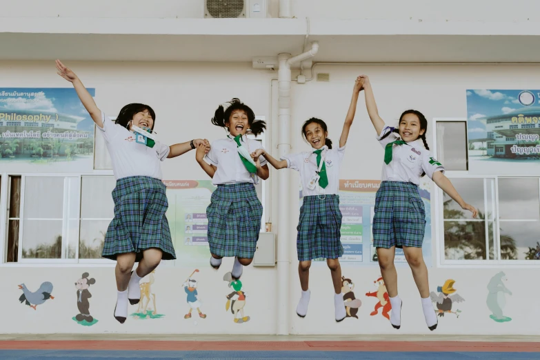 a group of girls jumping in the air, a picture, by Maeda Masao, danube school, background image, maintenance photo, image, inside elementary school