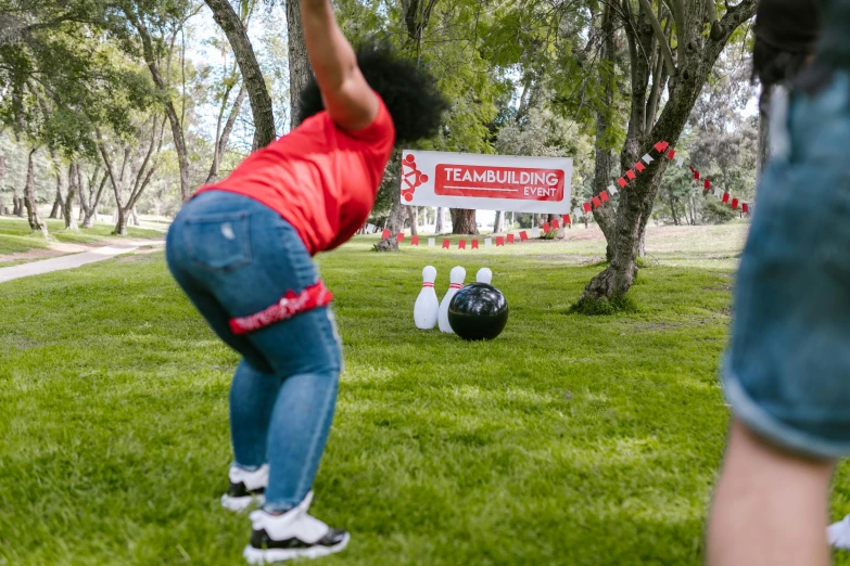 two people playing a game of bowling in a park, happening, holding a red banner, curvy crossfit build, line dancing at a party, 2019 trending photo