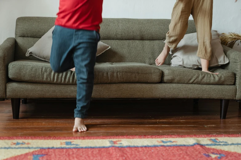 a couple of people standing on top of a couch, a child's drawing, pexels contest winner, red carpeted floor, running fast towards the camera, head down, muted colors with minimalism