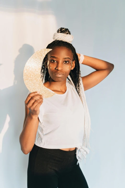 a woman in a white top and black pants, inspired by Theo Constanté, trending on unsplash, afrofuturism, headpiece headpiece headpiece, half moon, white straw flat brimmed hat, cardboard cutout