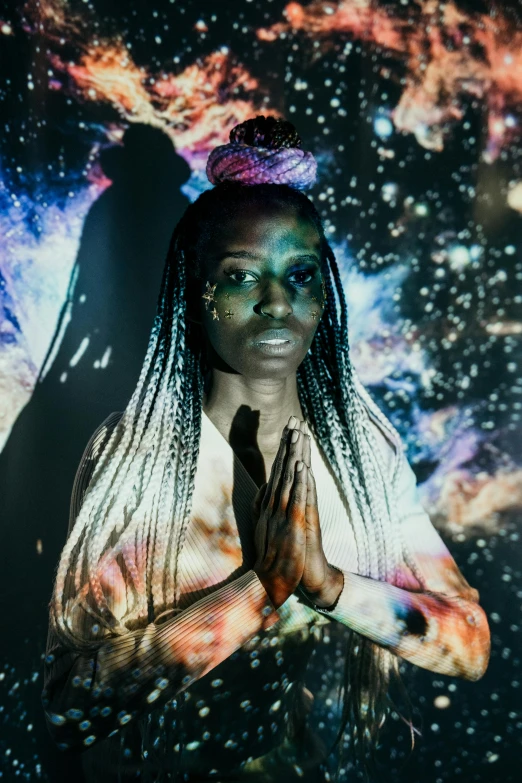 a woman with dreadlocks standing in front of a galaxy background, inspired by Ras Akyem, afrofuturism, concert photo, in a black room, deity), iridescent skin