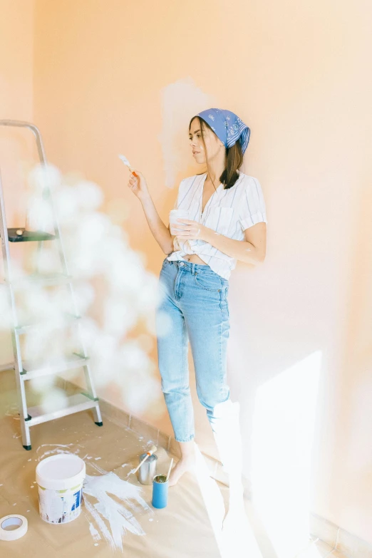 a woman that is standing in the corner of a room, a painting, trending on pexels, pastel colour palette, blue jeans, gardening, young asian woman