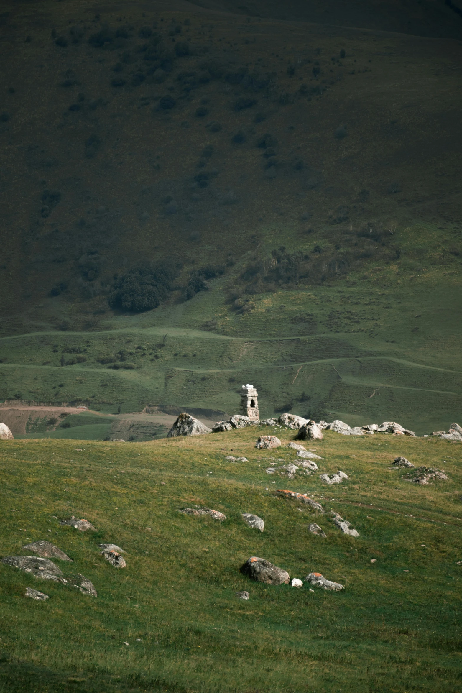 a herd of sheep grazing on a lush green hillside, by Muggur, unsplash contest winner, les nabis, dark ruins landscape, distant hooded figures, lonely rider, boulders