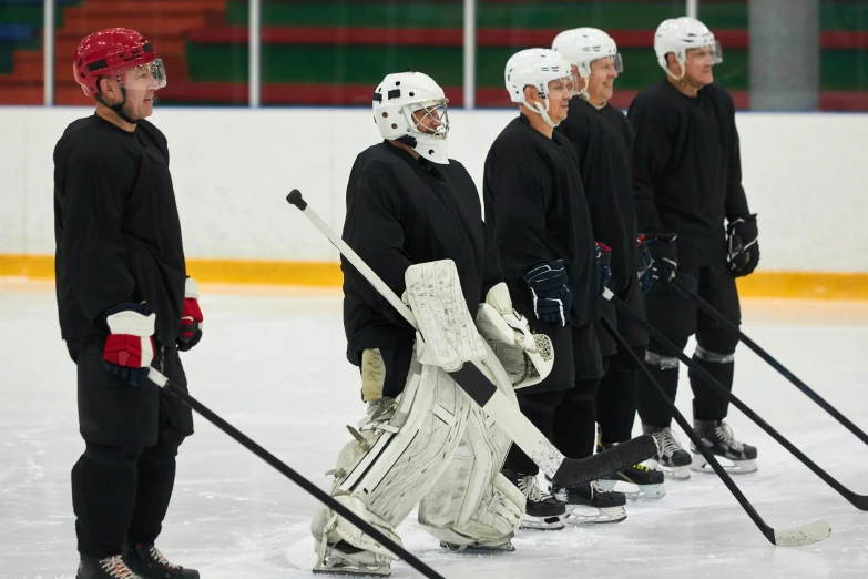 a group of men standing next to each other on top of an ice rink, full ice hockey goalie gear, practice, afp, left profile