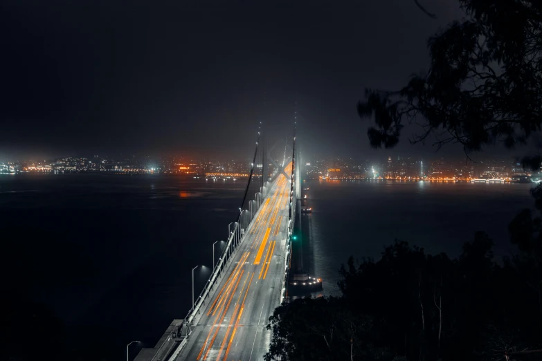 a long bridge over a body of water at night, pexels contest winner, hyperrealism, san francisco, hazy, vehicle photography, ilustration