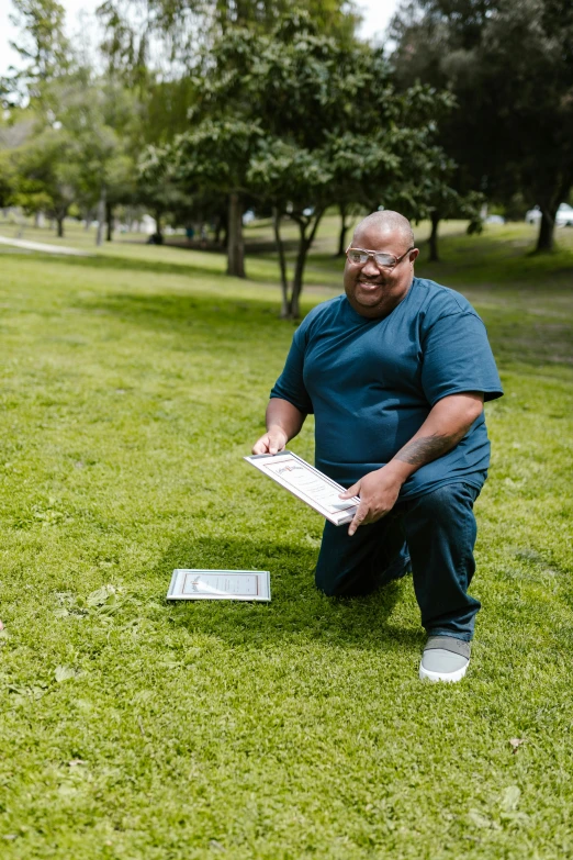 a man standing on top of a lush green field, with book of science, non-binary, at a park, morbidly obese