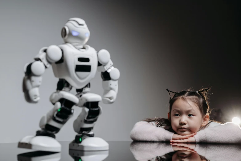 a little girl sitting in front of a robot, inspired by Ai Xuan, pexels contest winner, eva elfie, humanoid animal, studio photo, istockphoto