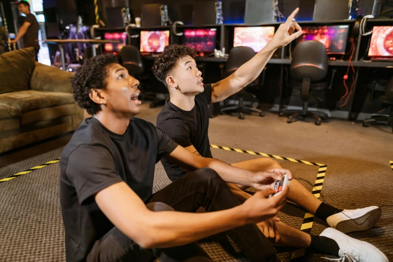 two young men sitting on the floor playing a video game, pexels, interactive art, space high school, avatar image, in a planet fitness, black teenage boy