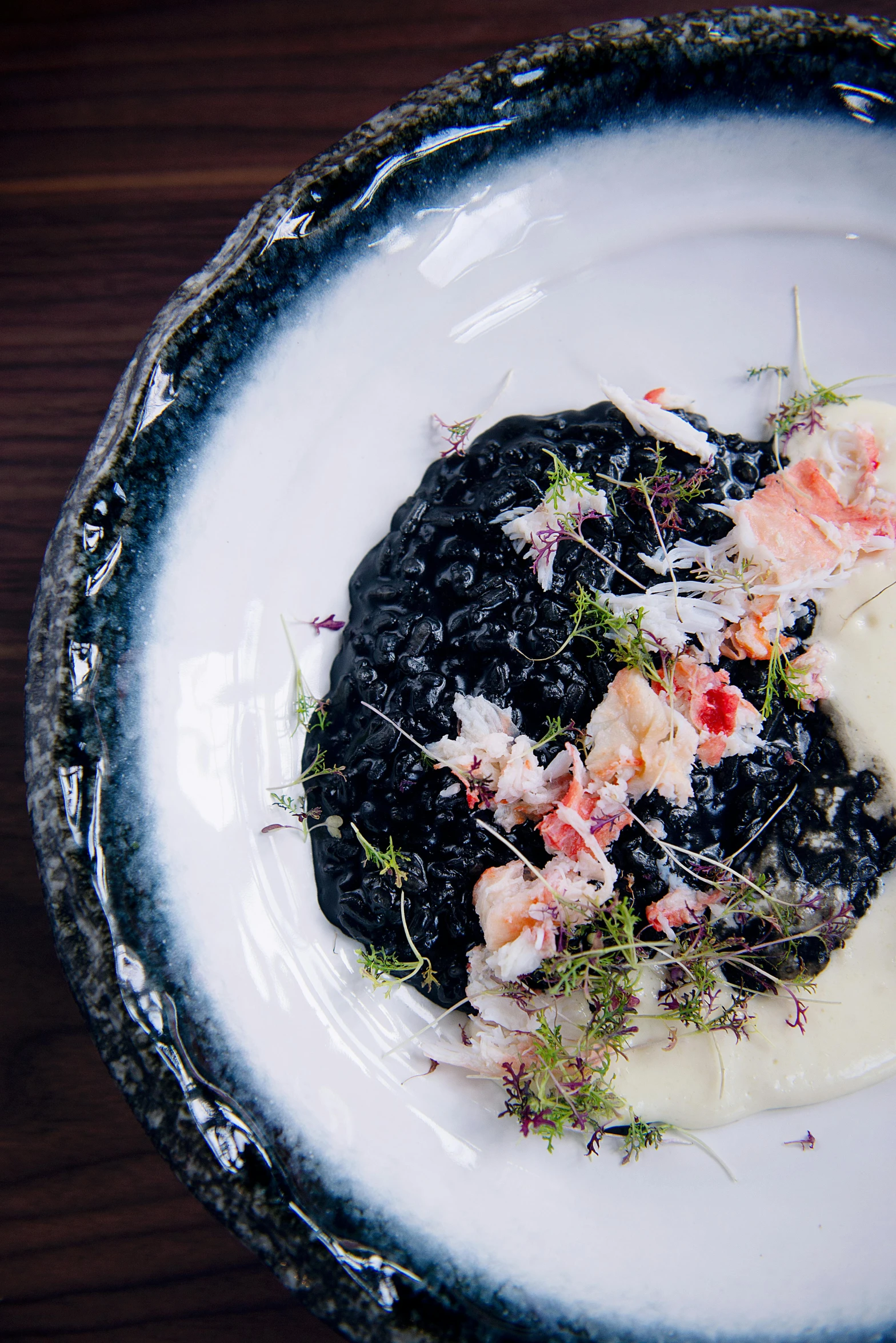 a close up of a plate of food on a table, inspired by Patrick Pietropoli, unsplash, made of smooth black goo, crab, creamy, colombian