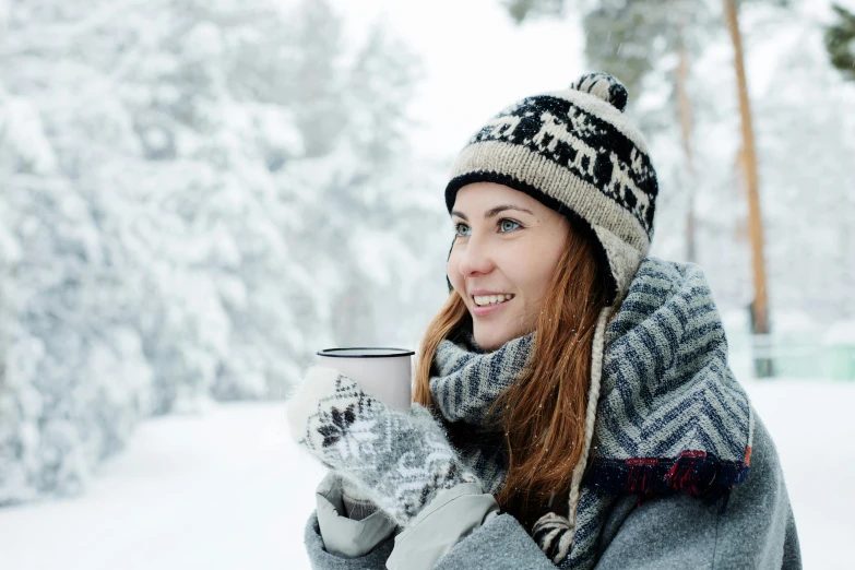 a woman holding a cup of coffee in the snow, inspired by Louisa Matthíasdóttir, pexels contest winner, hurufiyya, wearing a cute hat, avatar image, scandinavian, grey