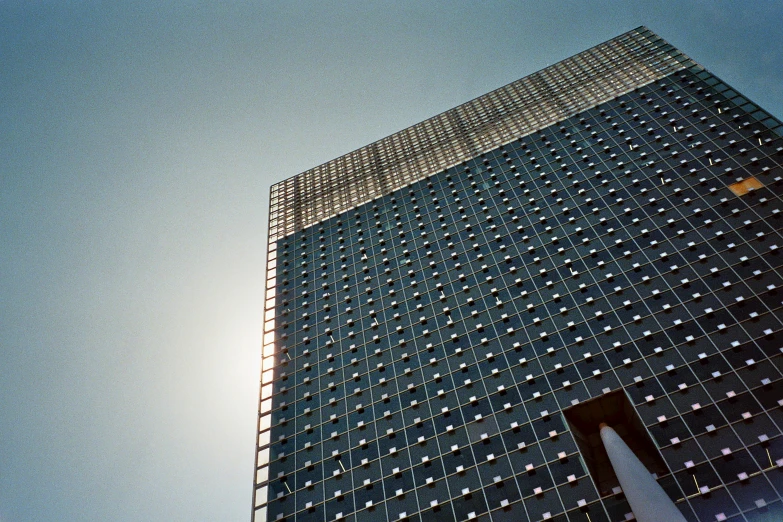 a very tall building with a lot of windows, an album cover, by Jiro Yoshihara, unsplash, brutalism, 3 5 mm slide, sparkling in the sunlight, beijing, low angle photograph