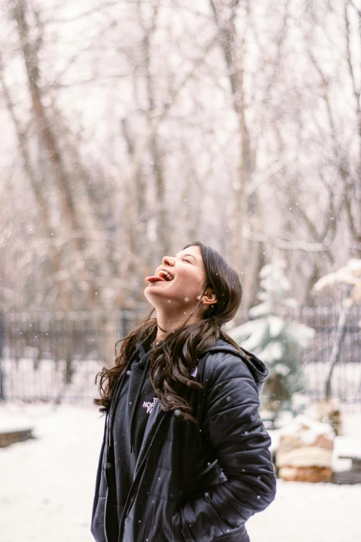 a woman standing in the snow with her eyes closed, pexels contest winner, laughing hysterically, alexandria ocasio cortez, nature outside, liv tyler