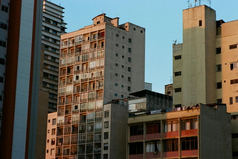 a group of tall buildings sitting next to each other, a photo, inspired by Elsa Bleda, unsplash, brutalism, location ( favela ), late afternoon light, 2000s photo