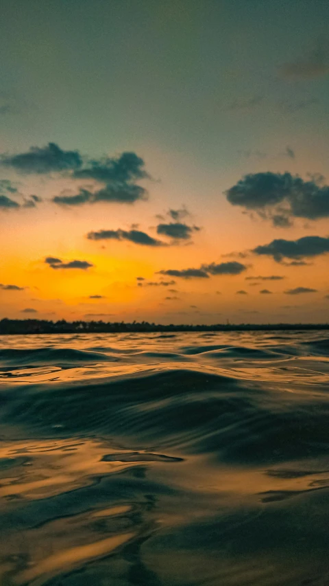 a large body of water with a sunset in the background, wavy, postprocessed, high-quality photo, 8k octan photo