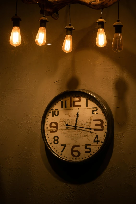 a clock and some light bulbs on a wall, cafe lighting, muted lighting, artificial warm lighting, paul barson