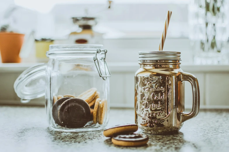 a jar of cookies next to a jar of cookies, a still life, by Julian Allen, pexels contest winner, drinks, brass and copper, thumbnail, small
